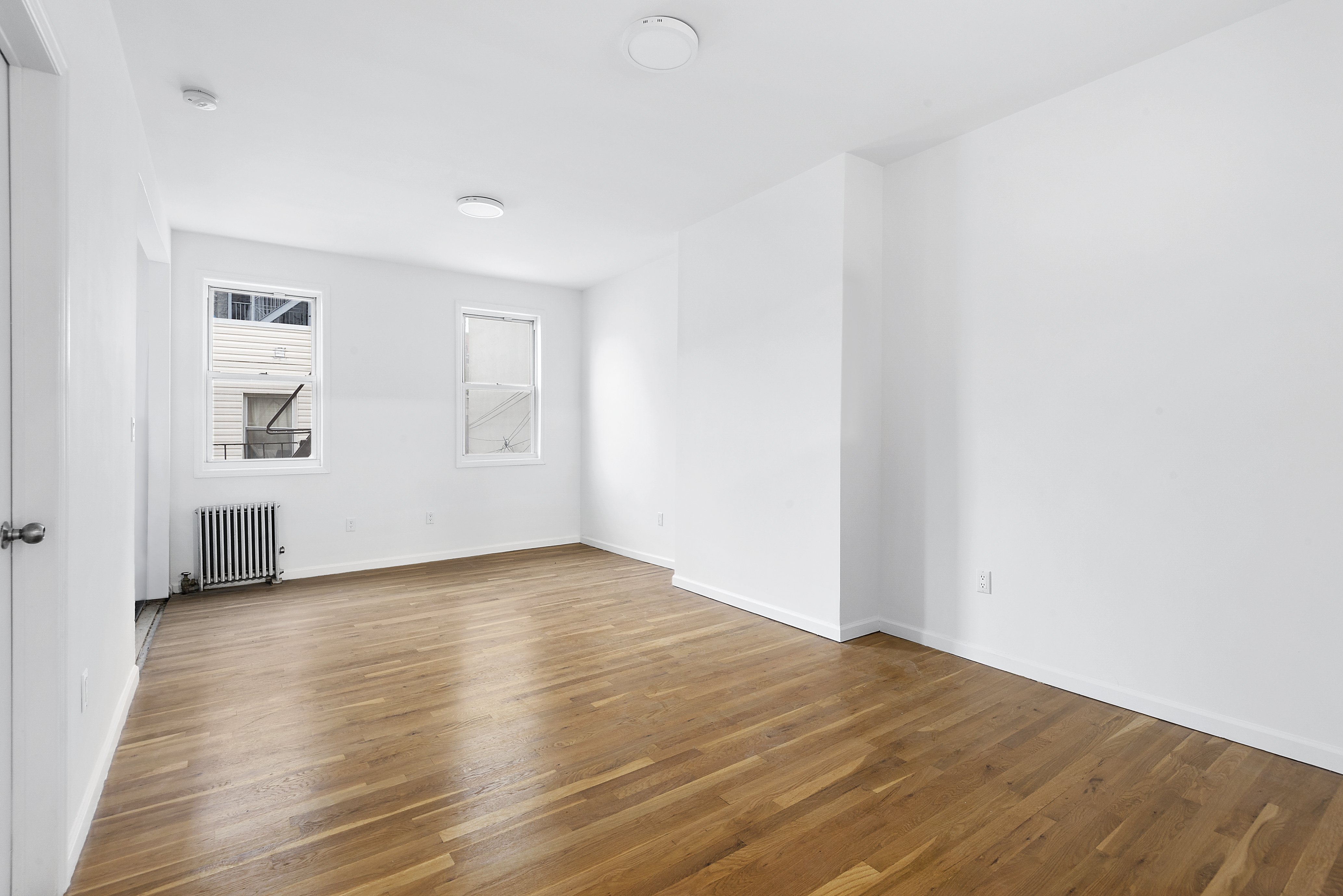 59 Stagg Street, Unit 3 Brooklyn, NY 11206 - Photo 2 of 8 a view of empty room with wooden floor and fan