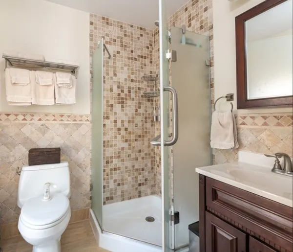 a bathroom with a sink a toilet and shower