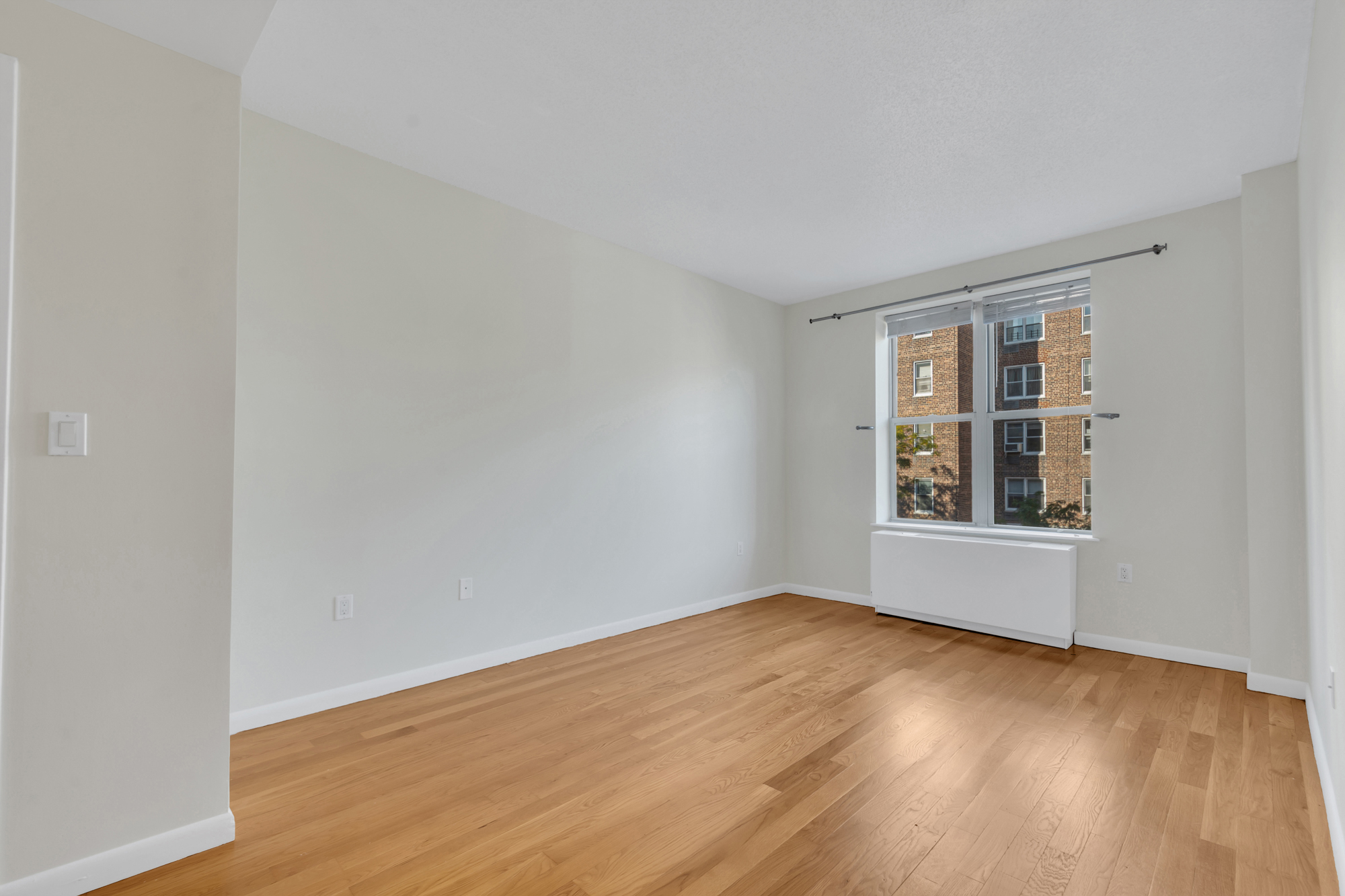 736 West 187th Street, Unit 502 Manhattan, NY 10033 - Photo 7 of 11 a view of an empty room with wooden floor and a window