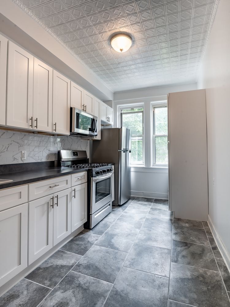 a kitchen with stainless steel appliances granite countertop a stove a sink and a refrigerator