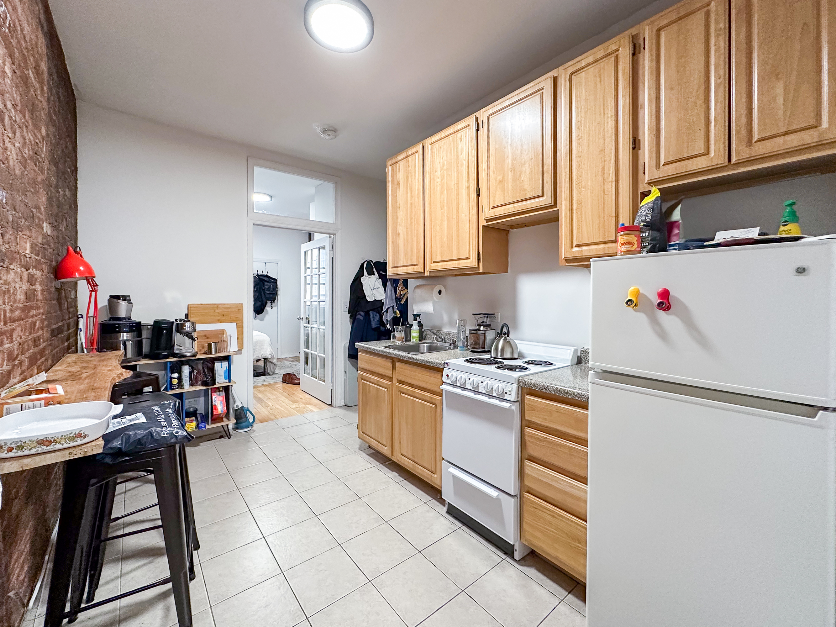 213 East 5th Street, Unit 5 Manhattan, NY 10003 - Photo 9 of 17 a kitchen with stainless steel appliances granite countertop a refrigerator sink and cabinets