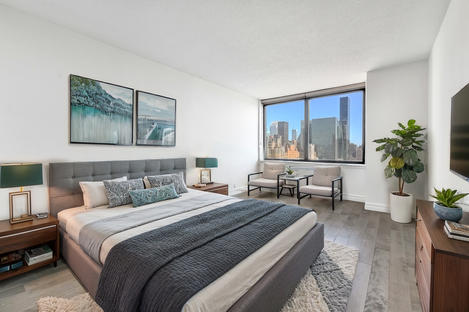 415 East 37th Street, Unit 32G Manhattan, NY 10016 - Photo 2 of 19 a bedroom with a large bed and a couch