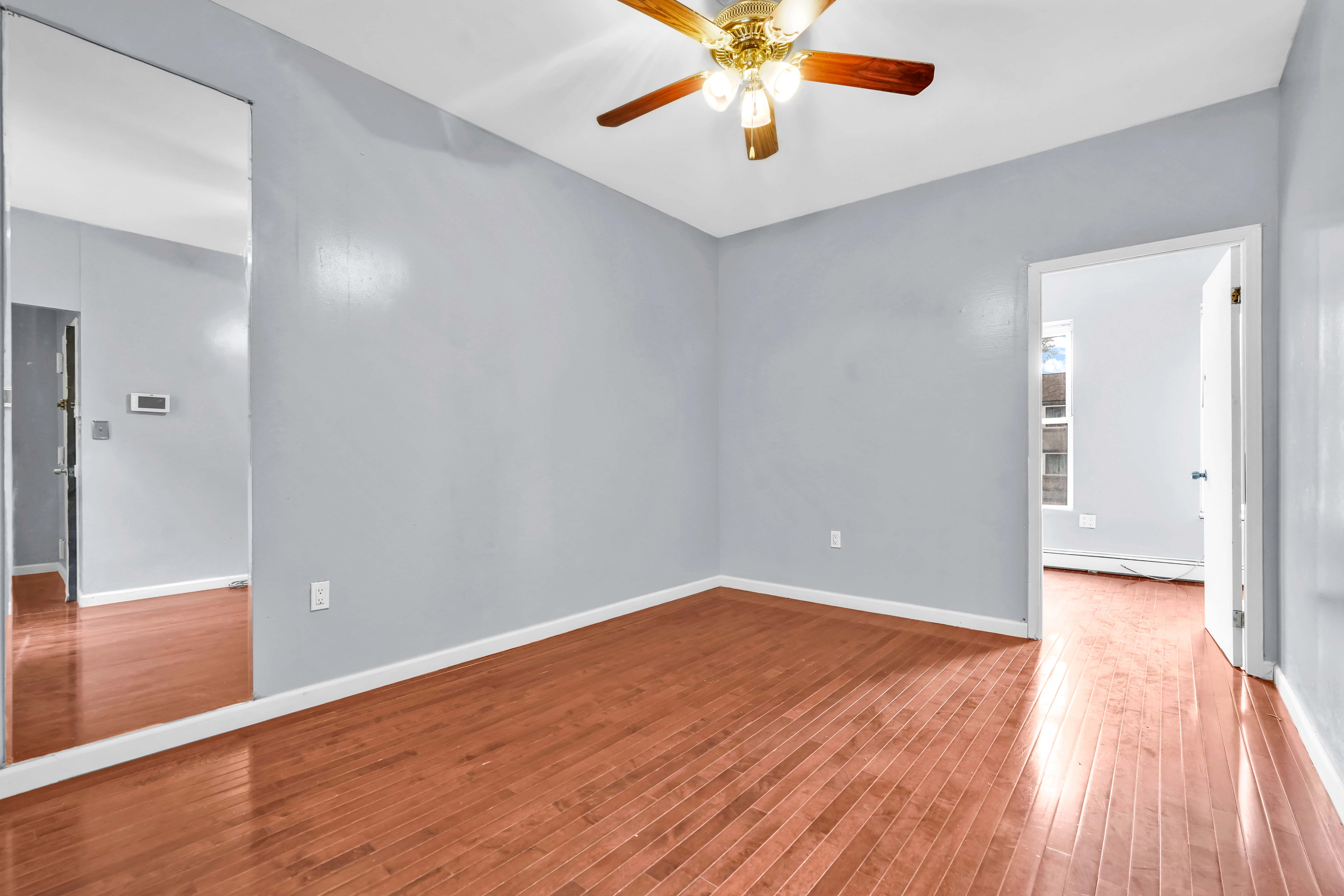1633 St Johns Place, Unit 3 Brooklyn, NY 11233 - Photo 7 of 29 wooden floor in an empty room with a window
