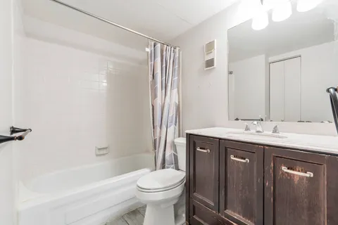 a bathroom with a granite countertop sink toilet and shower