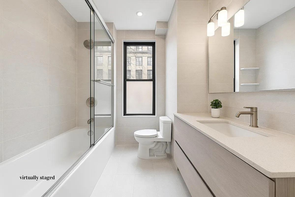 517 East 87th Street, Unit 1 Manhattan, NY 10128 - Photo 8 of 17 a bathroom with a sink a toilet and shower