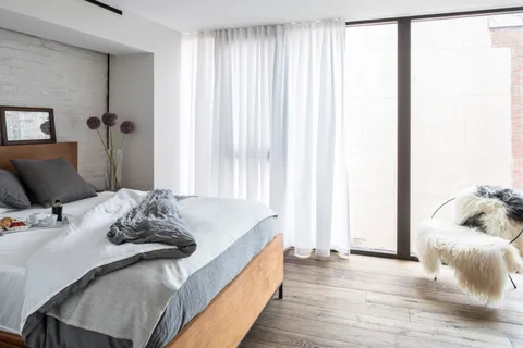 a bed sitting in a bedroom next to a window
