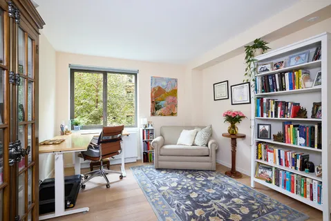 a living room with furniture and a book shelf