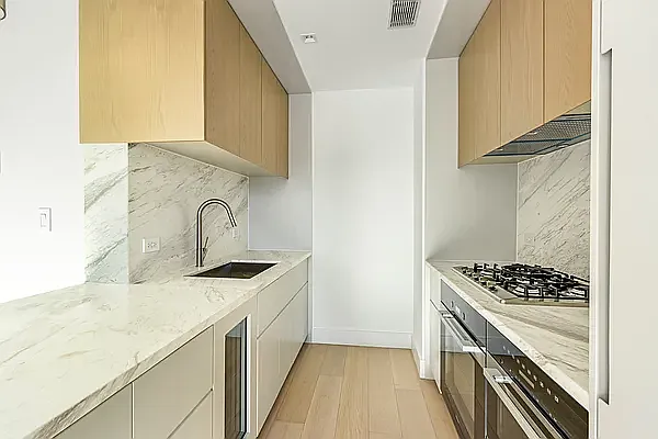 a kitchen with granite countertop a sink stove and cabinets
