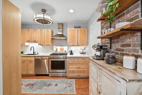 a kitchen with stainless steel appliances granite countertop a sink and a stove