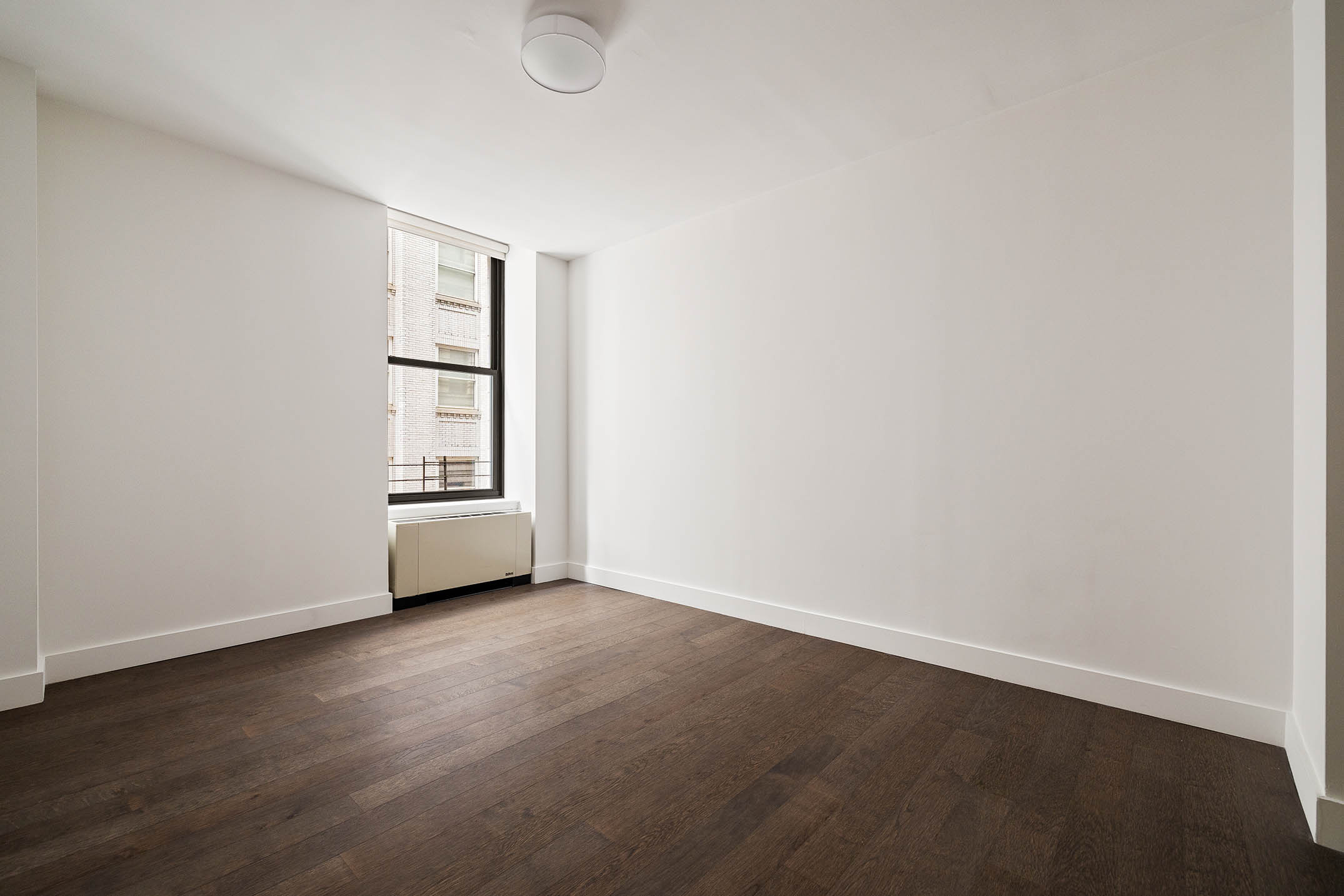 25 Broad Street, Unit 16I Manhattan, NY 10004 - Photo 14 of 23 an empty room with wooden floor and windows