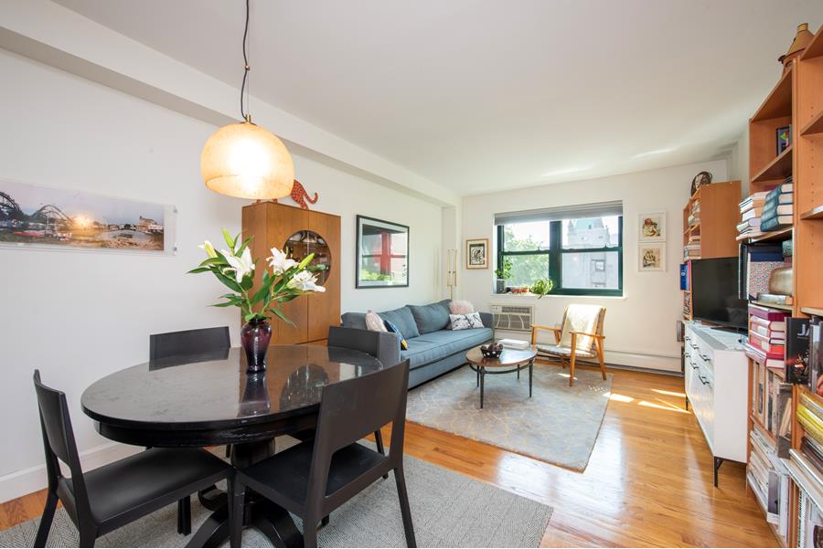 1885 Lexington Avenue, Unit 6D Manhattan, NY 10035 - Photo 2 of 7 a living room with furniture dining table and a flat screen tv