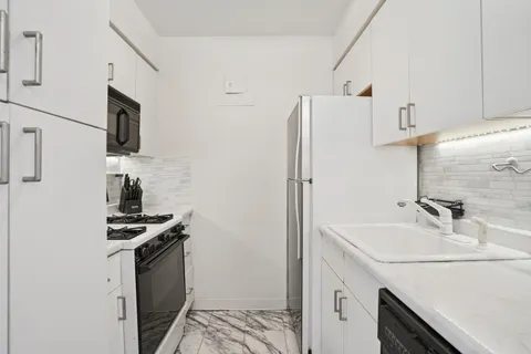 a kitchen with stainless steel appliances a sink stove and refrigerator