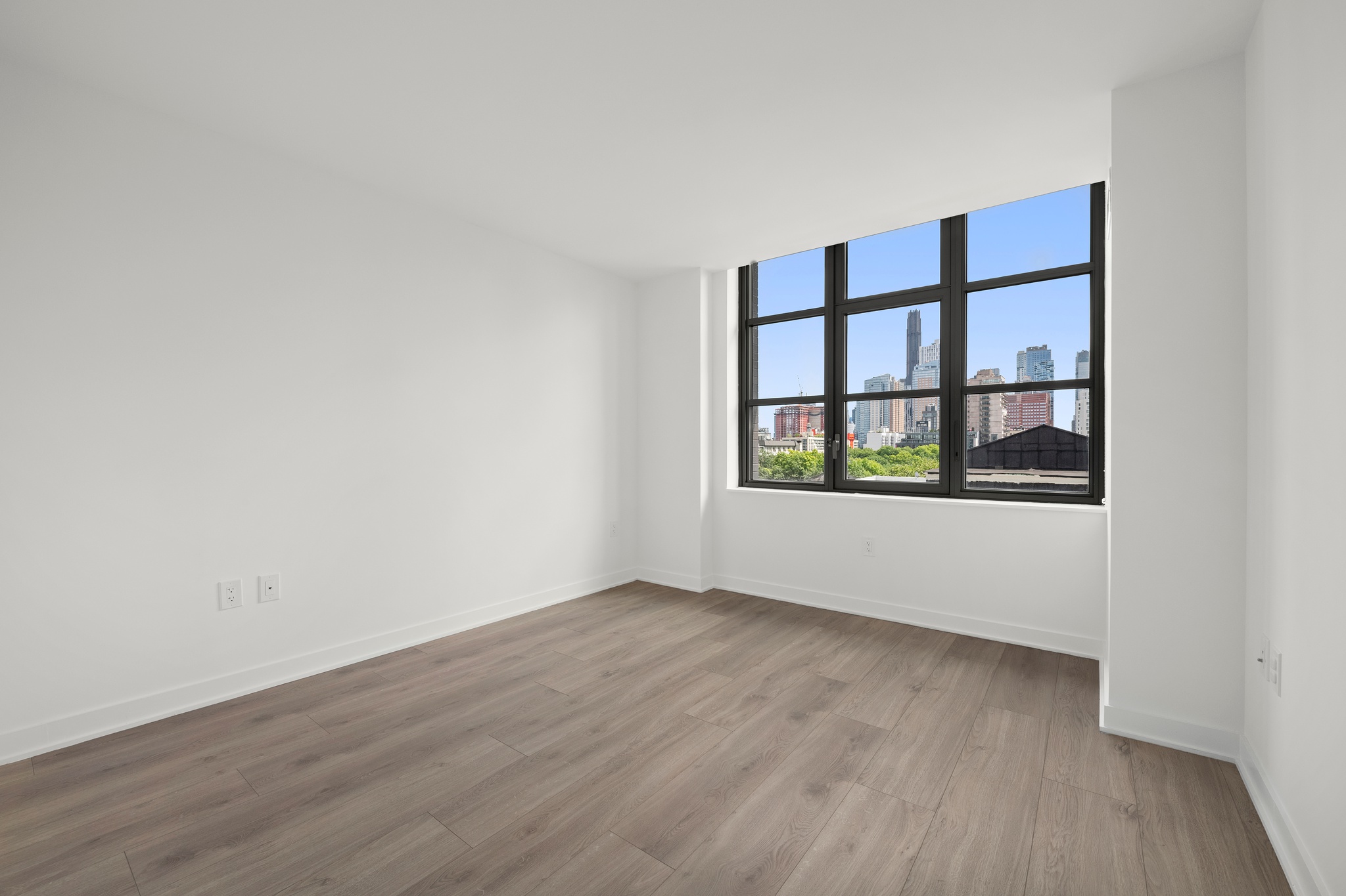 160 Front Street, Unit 706 Brooklyn, NY 11201 - Photo 10 of 17 a view of an empty room with wooden floor and a window