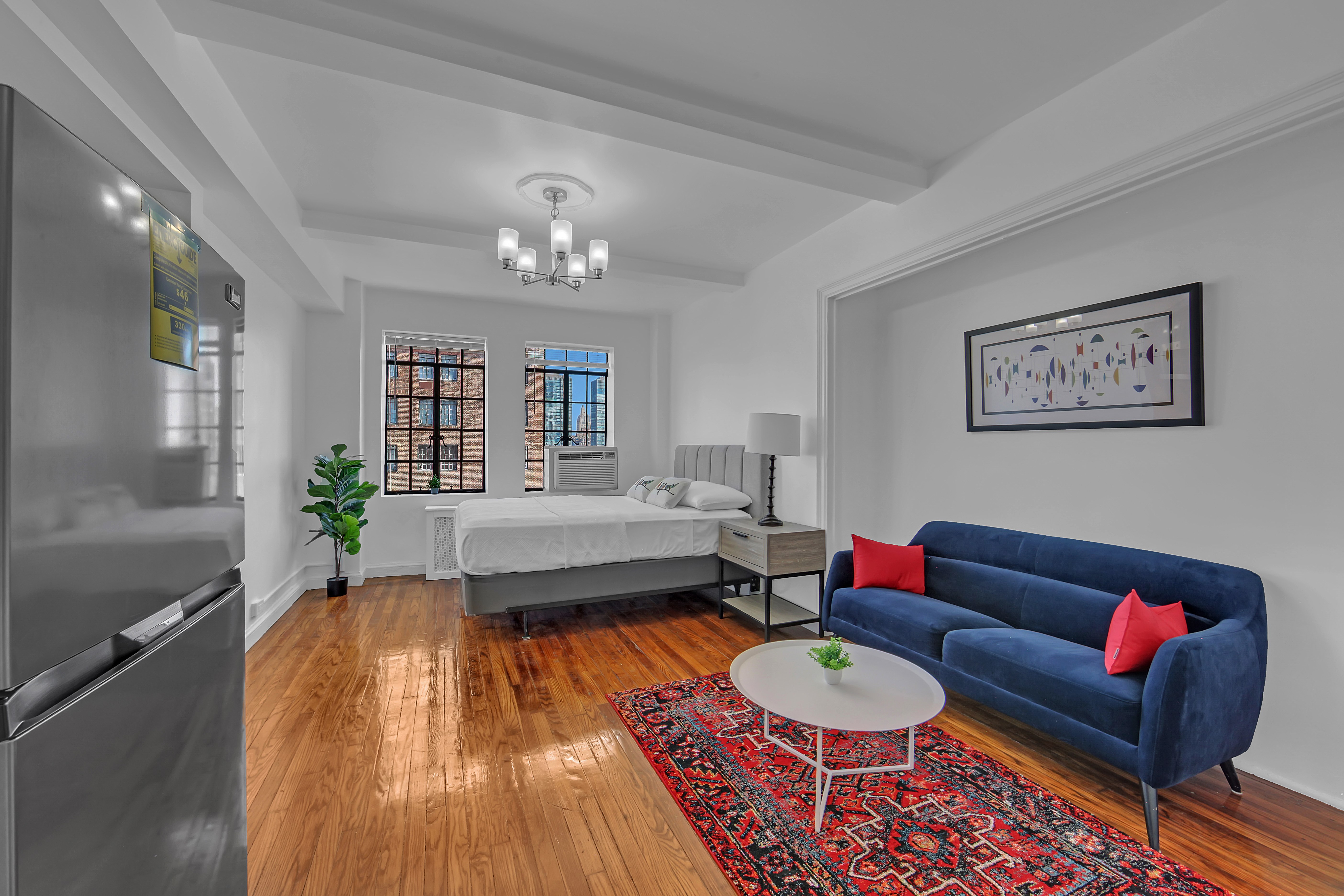 25 Tudor City Place, Unit 1202 Manhattan, NY 10017 - Photo 3 of 19 a living room with furniture and a wooden floor