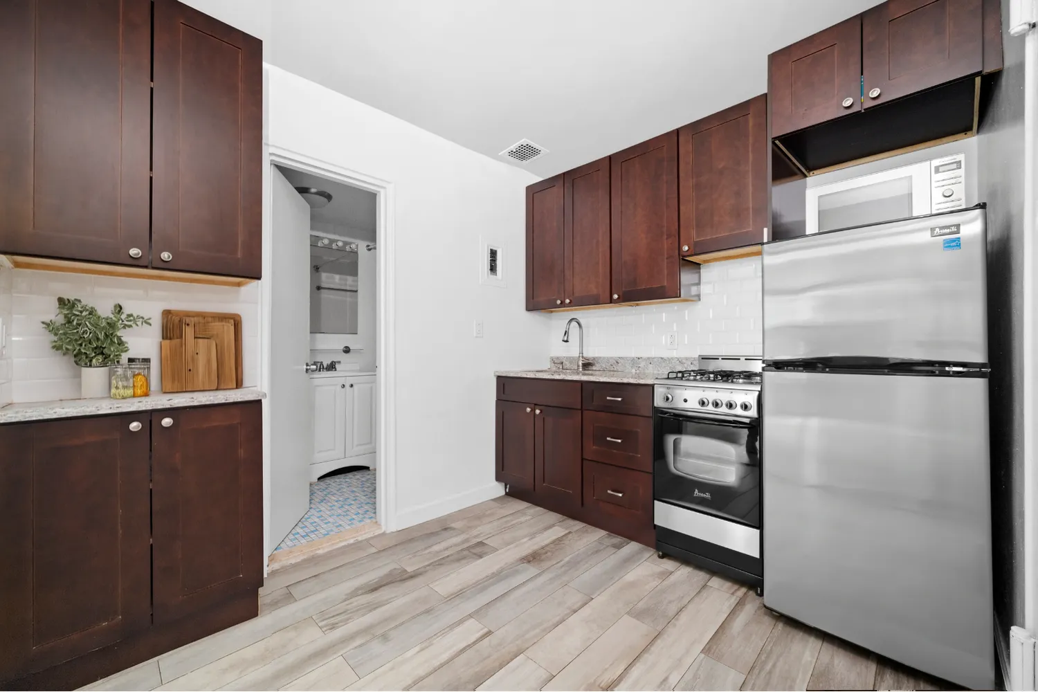 a kitchen with stainless steel appliances granite countertop a refrigerator stove and wooden cabinets