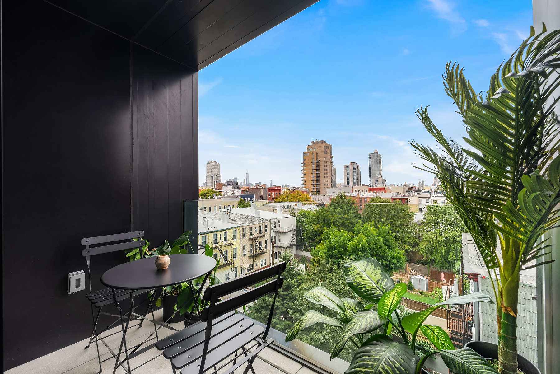 a balcony with a table and chairs and a potted plant