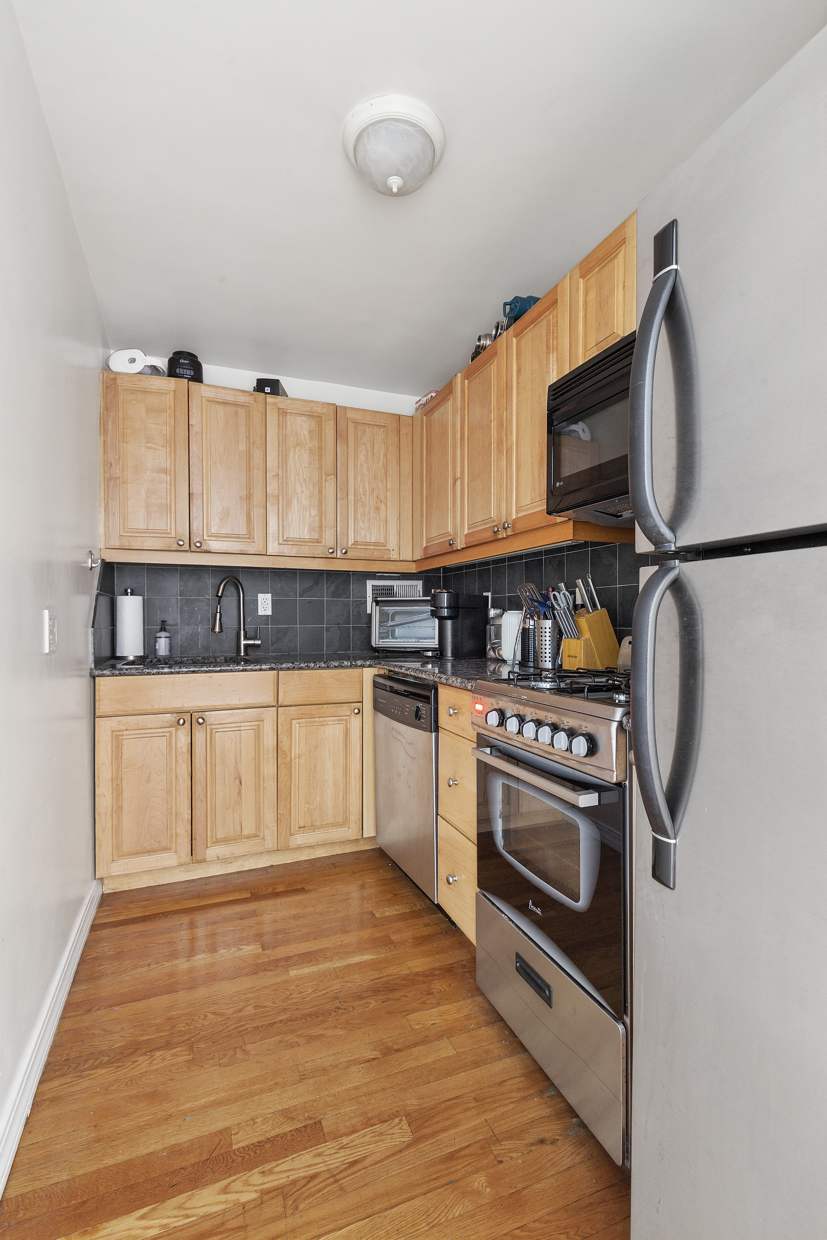 333 East 34th Street, Unit 14J Manhattan, NY 10016 - Photo 7 of 10 a kitchen with stainless steel appliances granite countertop a stove a sink and a refrigerator