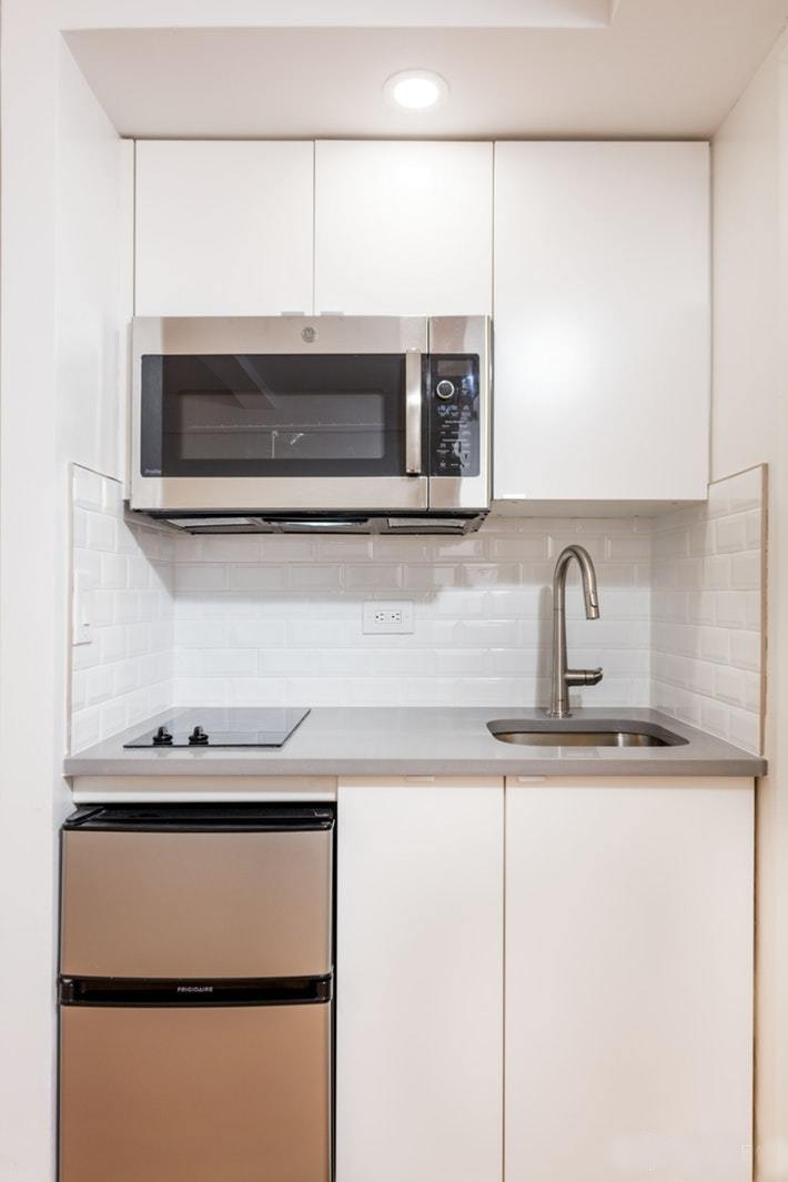 304 East 41st Street, Unit 502A Manhattan, NY 10017 - Photo 2 of 5 a kitchen with a sink and a microwave