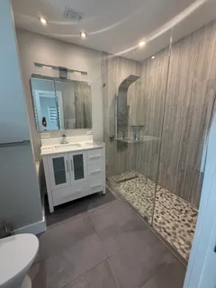 a bathroom with a double vanity sink toilet and shower