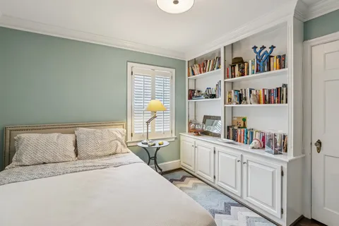 a bedroom with a bed a book shelf and a book shelf