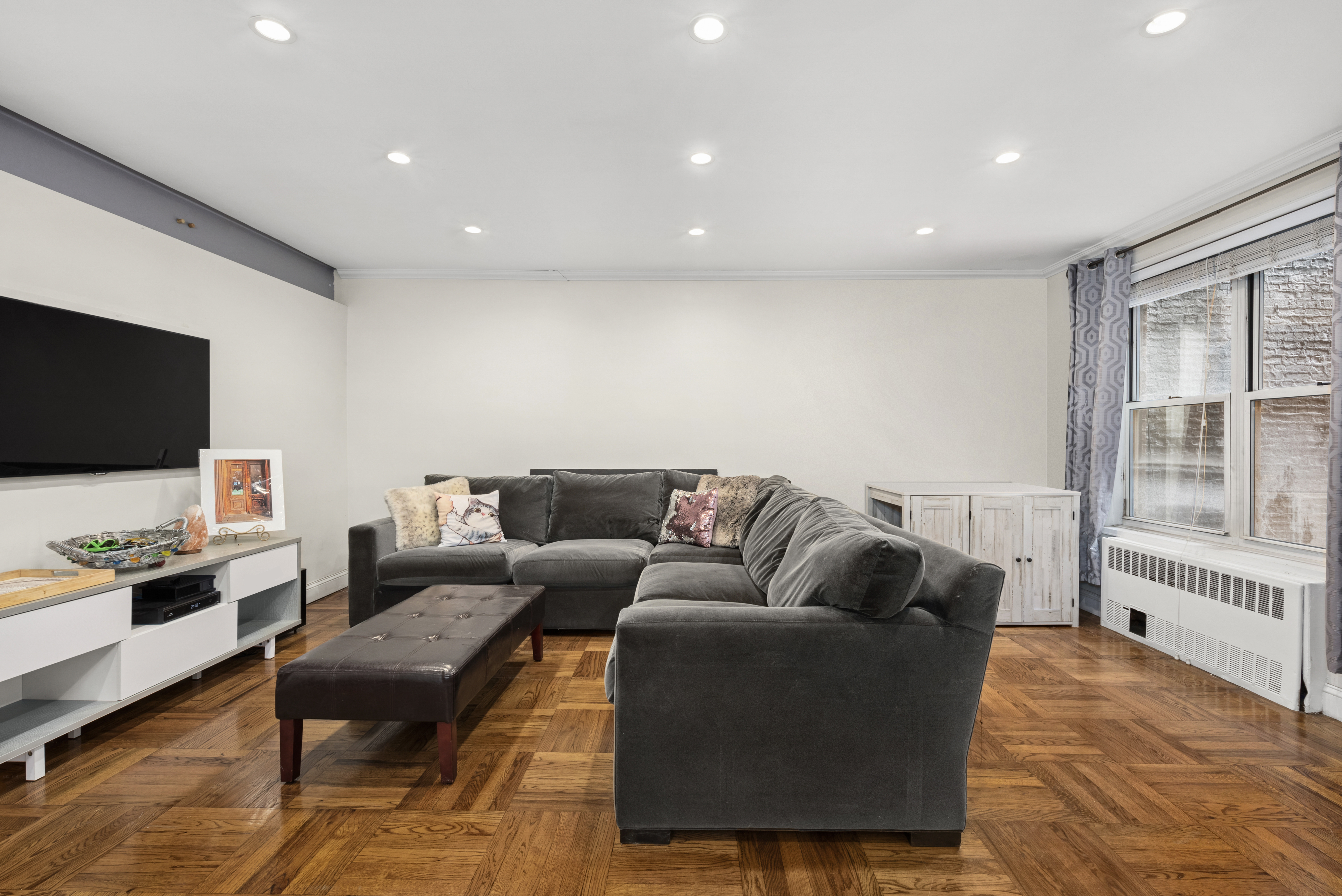 302 East 88th Street, Unit 2G Manhattan, NY 10128 - Photo 6 of 16 a living room with furniture and a flat screen tv