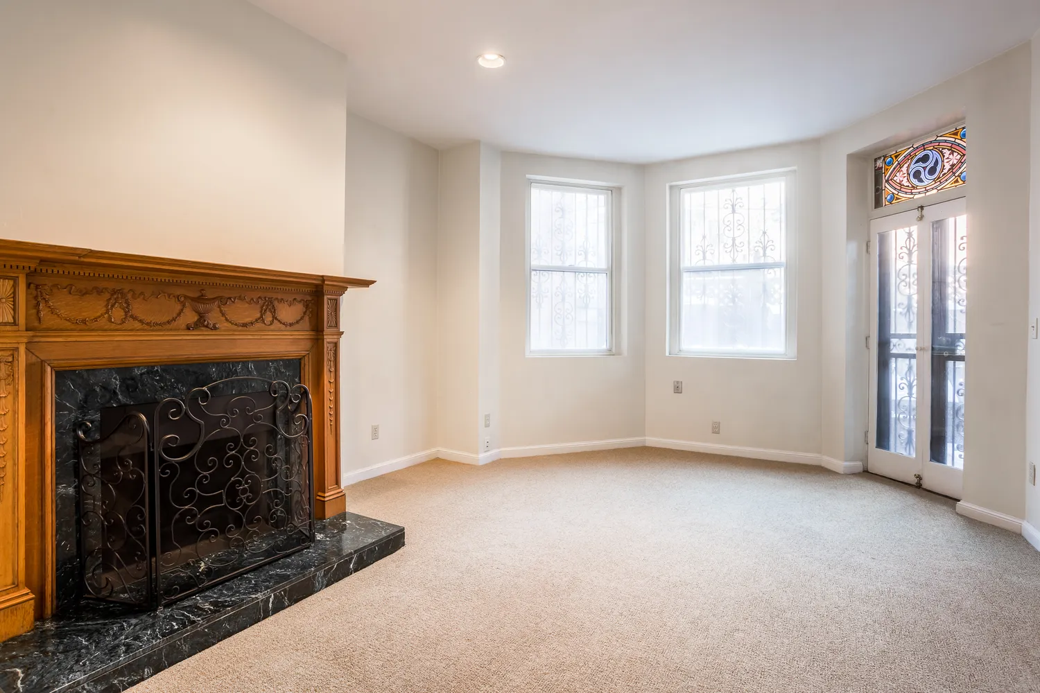 an empty room with windows and fireplace