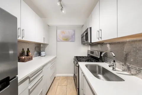 a kitchen with stainless steel appliances a sink a stove and cabinets
