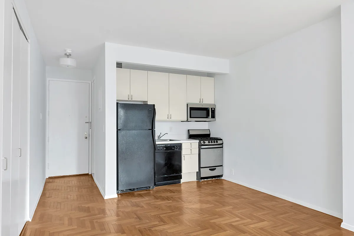 301 West 57th Street, Unit 22E Manhattan, NY 10019 - Photo 4 of 13 a view of kitchen with refrigerator stove and cabinets