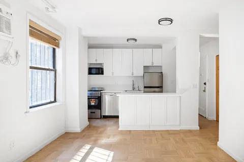 a living room with stainless steel appliances kitchen island granite countertop a stove and a refrigerator