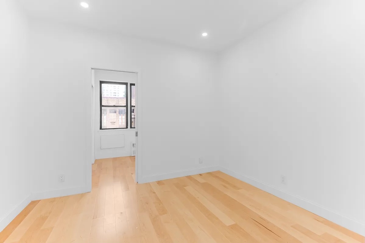 324 East 84th Street, Unit 1D Manhattan, NY 10028 - Photo 4 of 6 a view of empty room with wooden floor and fan