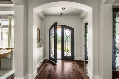 a dining room with wooden floor and glass windows