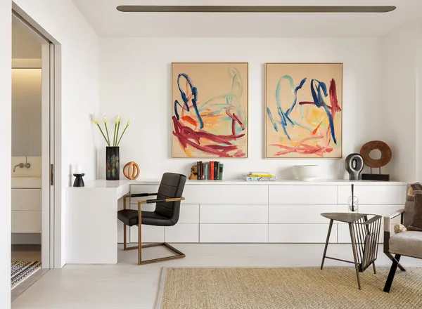 a living room with furniture and paintings on the wall