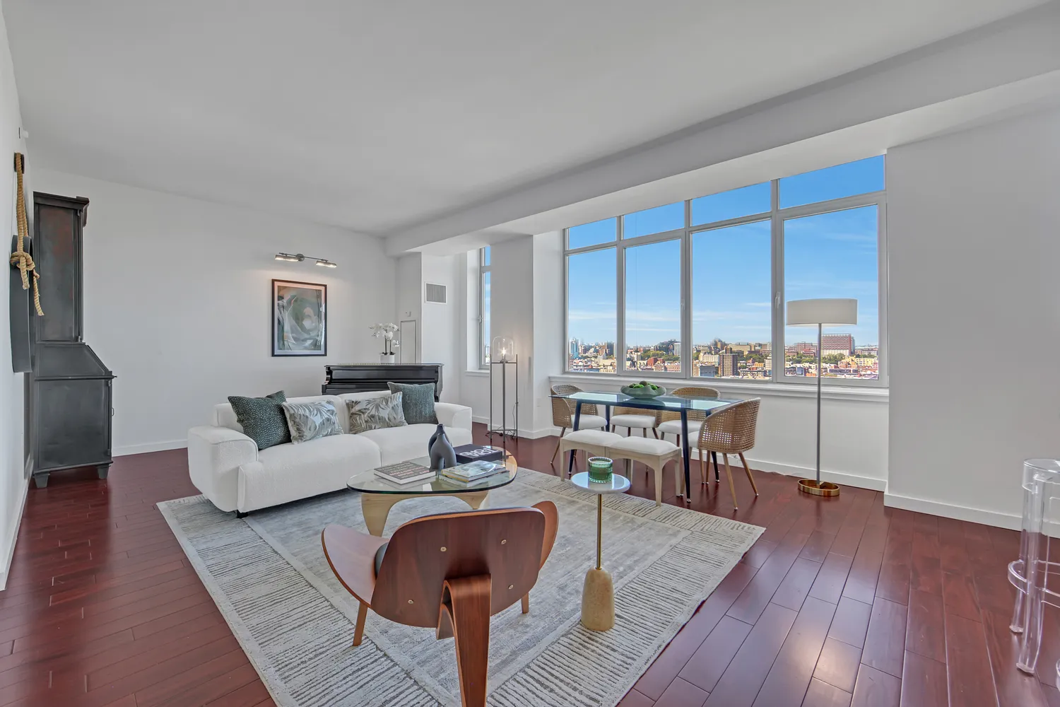a living room with couches chairs and kitchen view with wooden floor