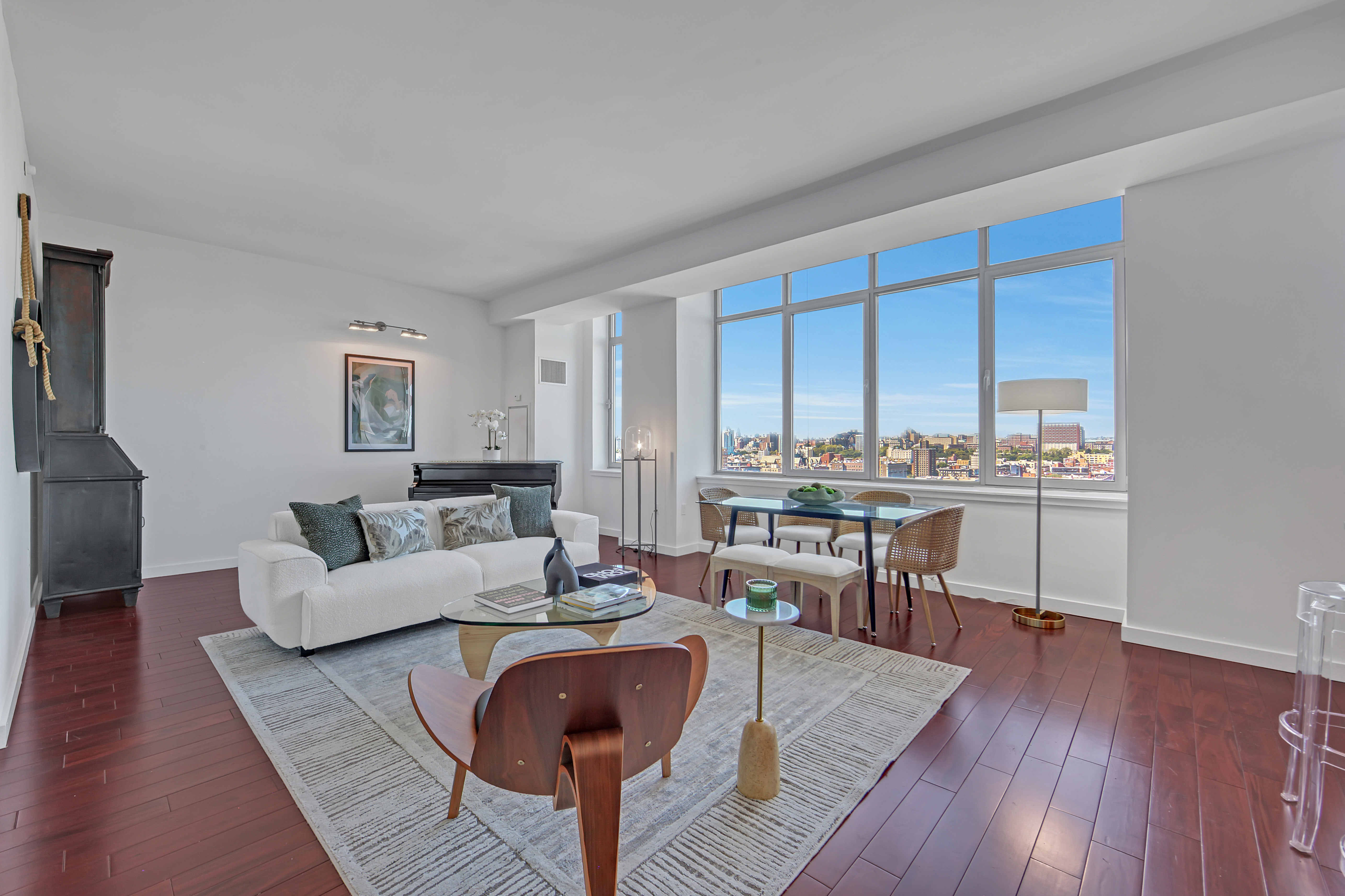 1485 5th Avenue, Unit 18/19H Manhattan, NY 10035 - Photo 2 of 24 a living room with couches chairs and kitchen view with wooden floor