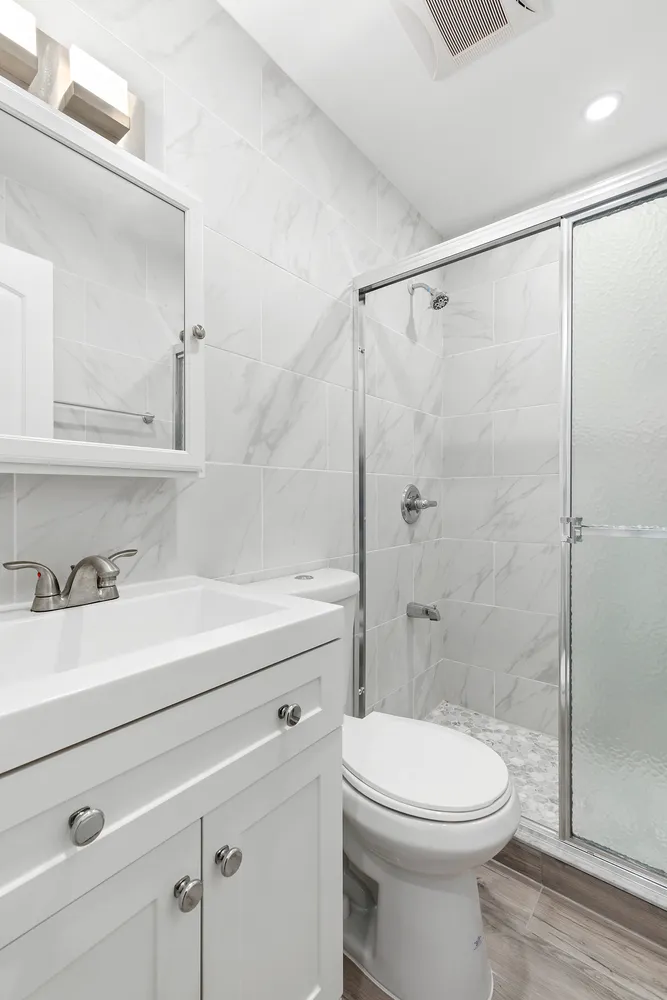 a bathroom with a sink a toilet and shower