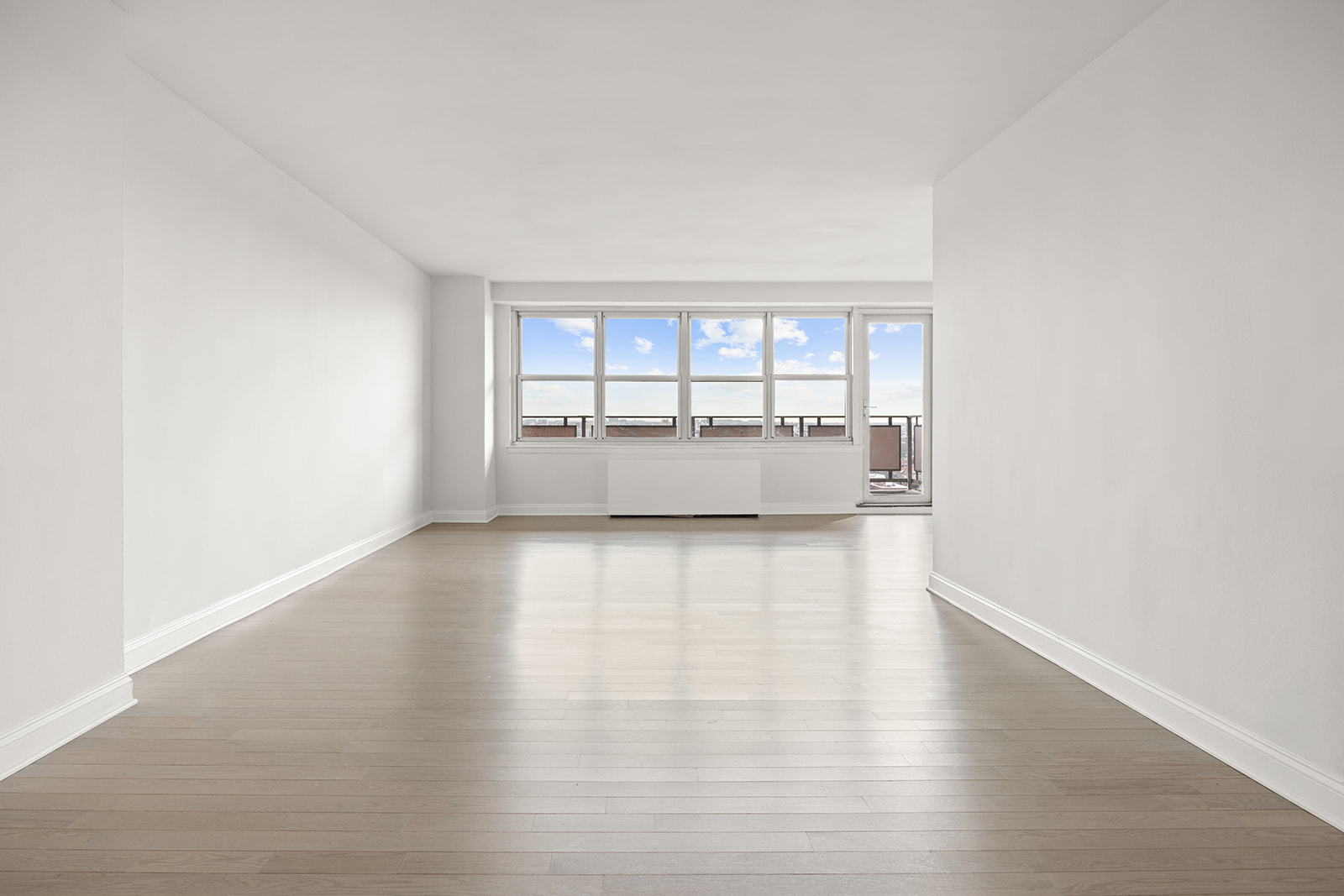 135 Ocean Parkway, Unit 16N Brooklyn, NY 11218 - Photo 3 of 16 an empty room with wooden floor and windows