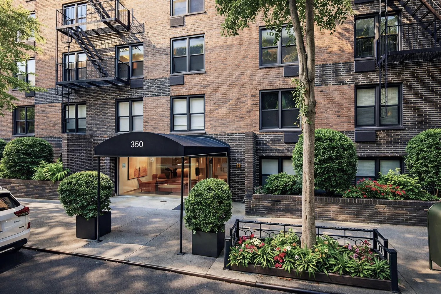 a front view of a building with a garden and plants