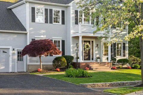 a front view of a house with a garden and plants