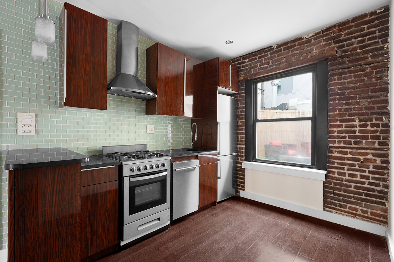 57 Grand Street, Unit 3 Manhattan, NY 10013 - Photo 3 of 6 a kitchen with a stove a sink and wooden floor