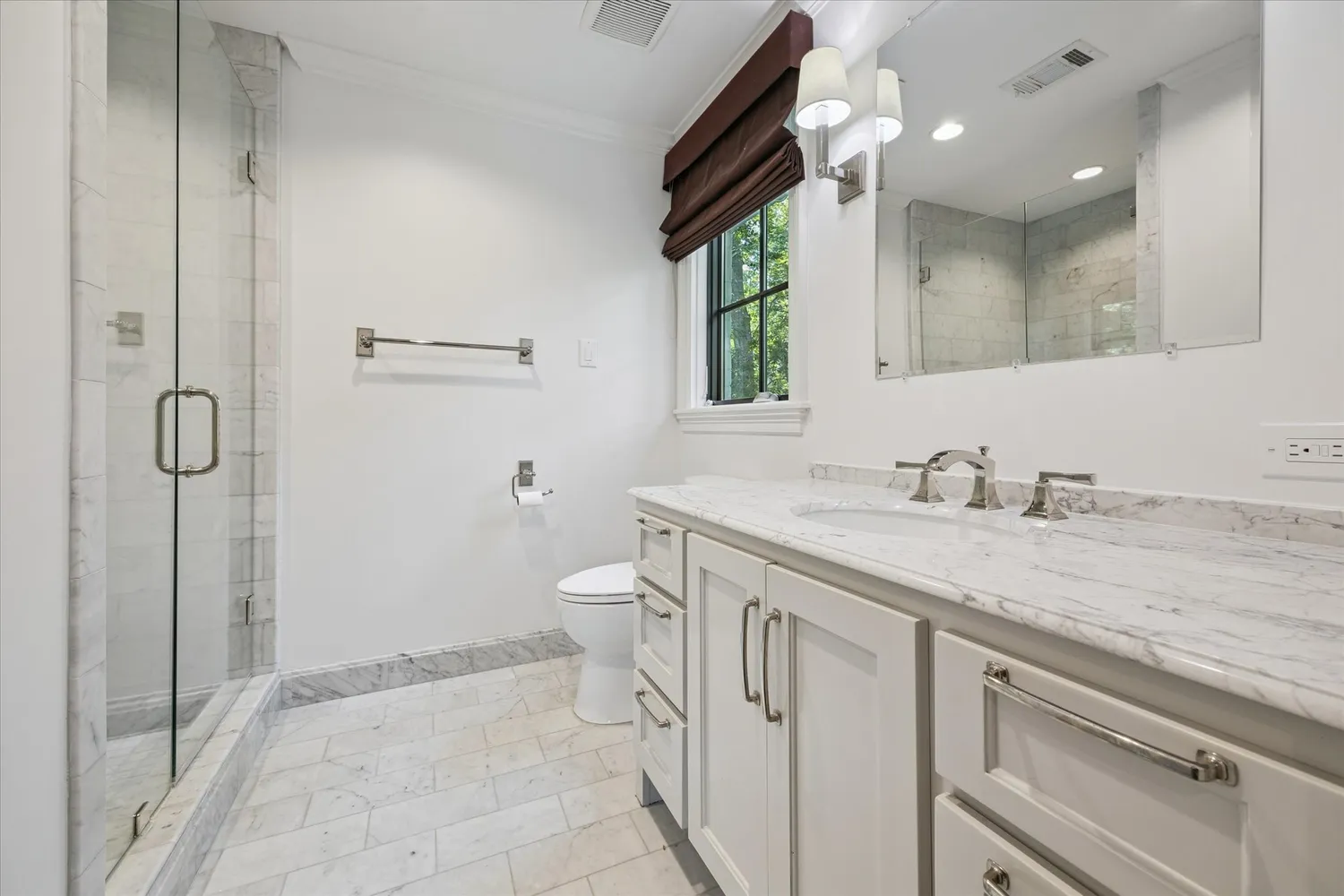 a bedroom with a bed a mirror and a lamp on table