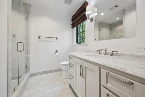 a bedroom with a bed a mirror and a lamp on table