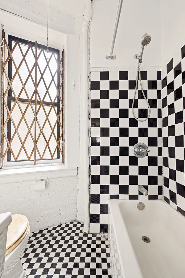 a bathroom with a black and white checkered floor