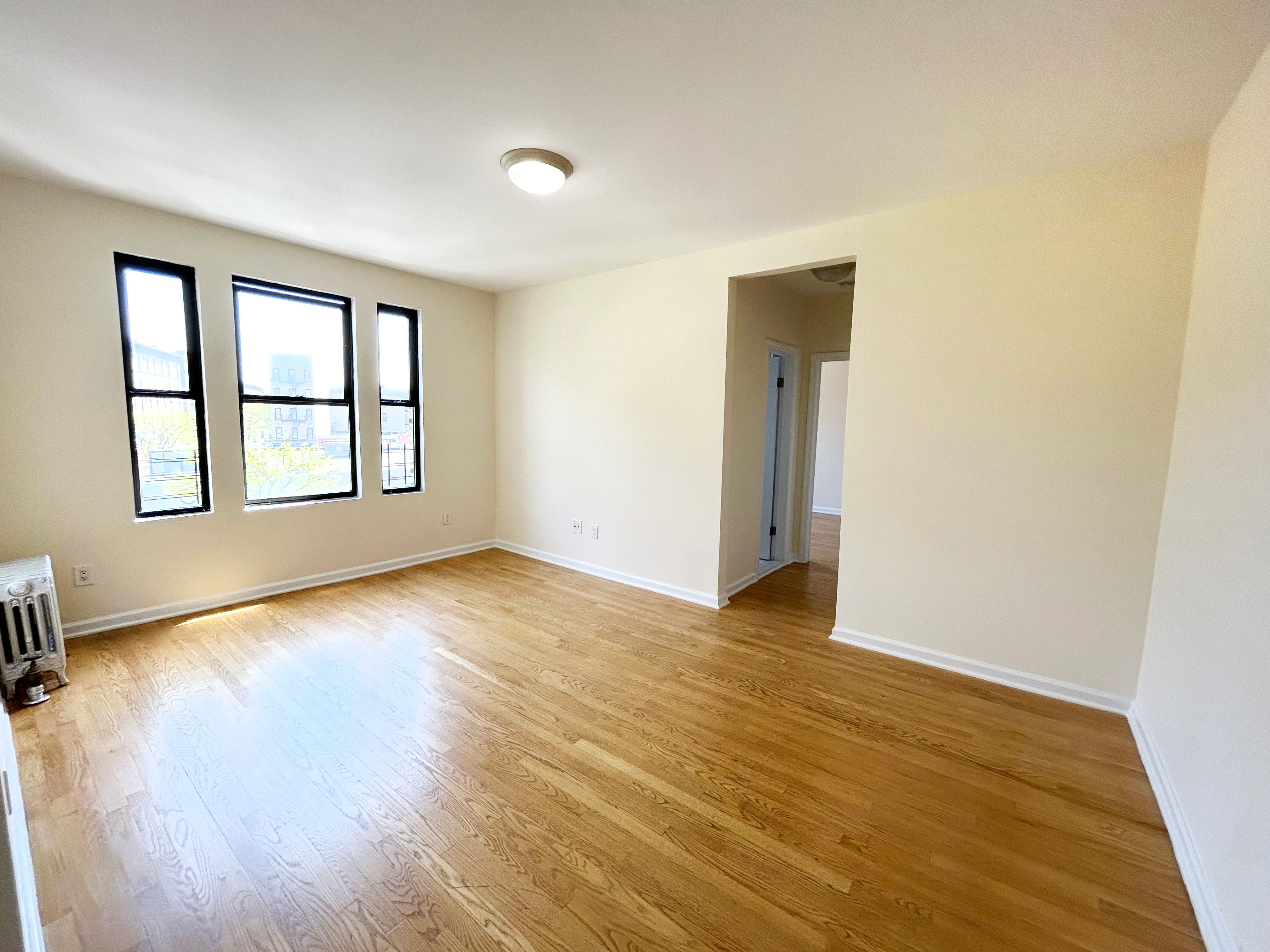 620 West 171st Street, Unit 3B Manhattan, NY 10032 - Photo 2 of 9 a view of an empty room with wooden floor and a window