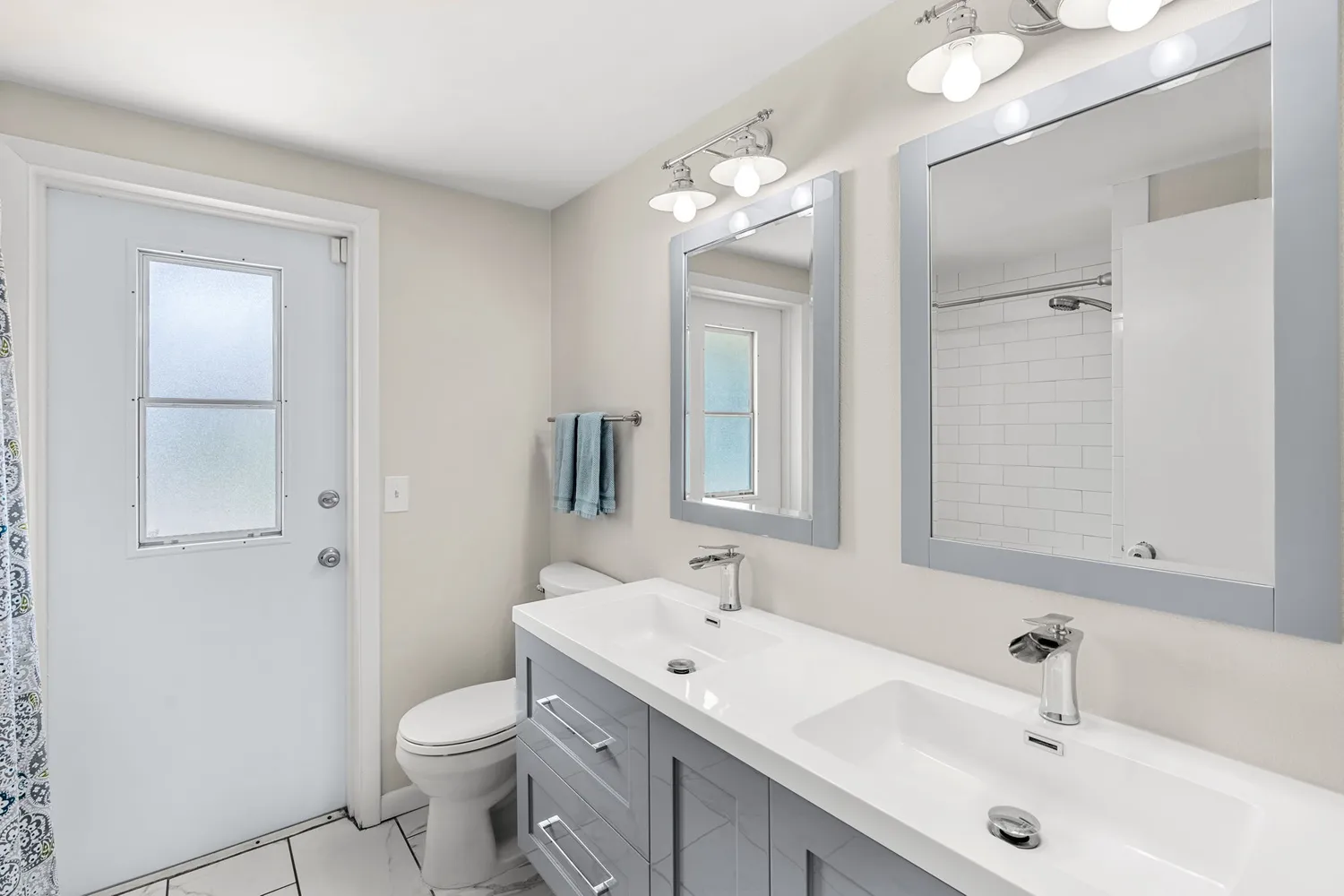 a bathroom with a sink a toilet and a large mirror