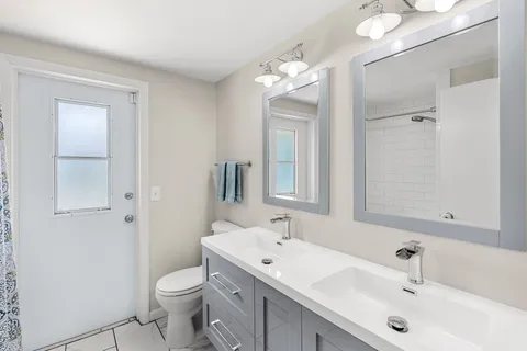 a bathroom with a sink a toilet and a large mirror