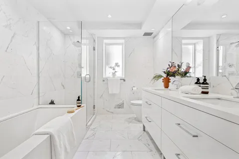 a spacious bathroom with a double vanity sink a large mirror a shower and bathtub