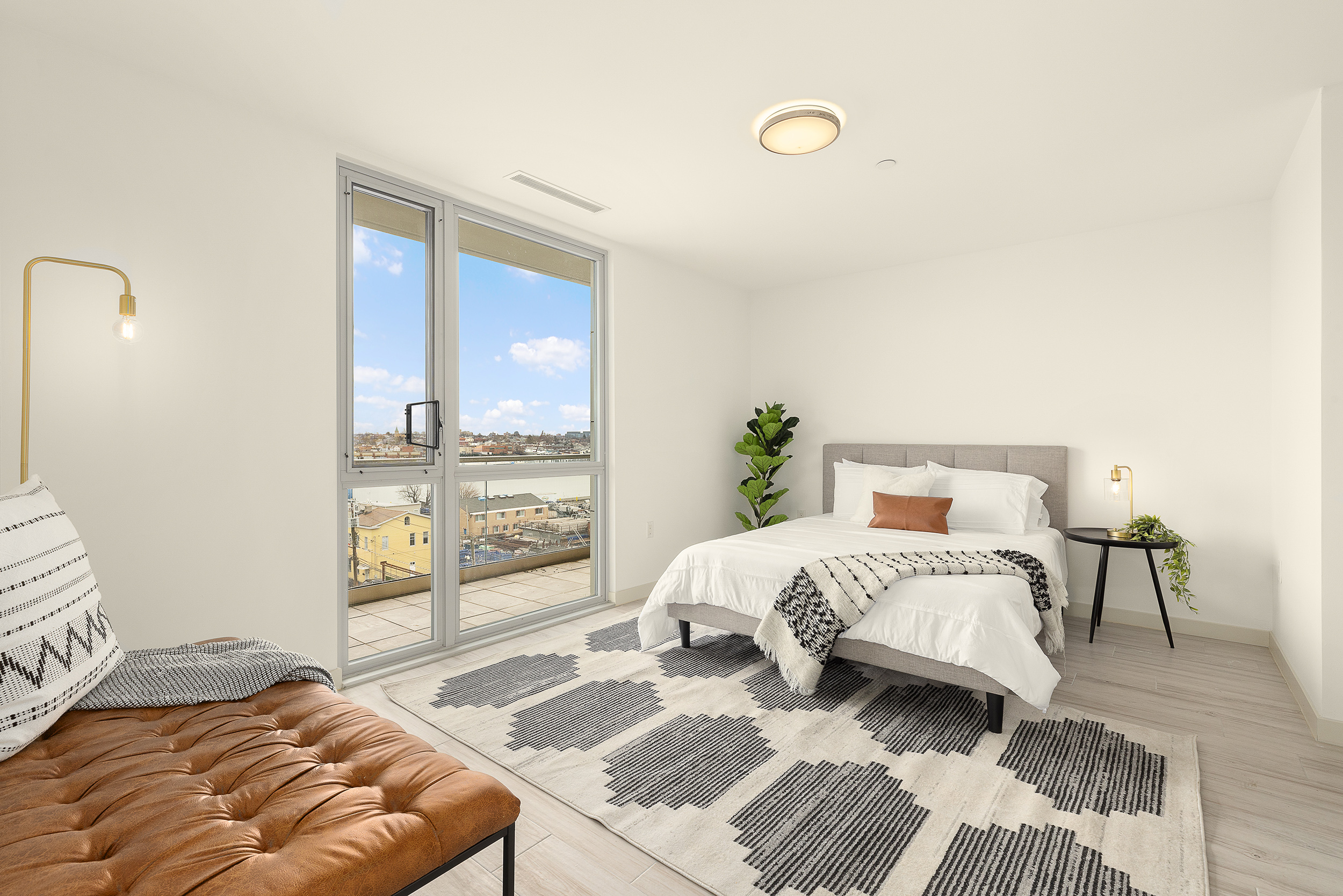 109-09 15th Avenue, Unit PHS611 Queens, NY 11356 - Photo 4 of 11 a bedroom with a large bed and a couch