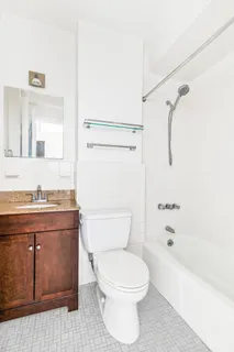 a bathroom with a granite countertop toilet a sink and a bathtub