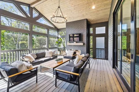 a living room with furniture a fireplace and a floor to ceiling window