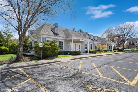 a front view of residential houses with yard and trees